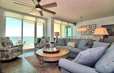 a living room with a couch and chairs and a table at Aqua 0502 in Panama City Beach
