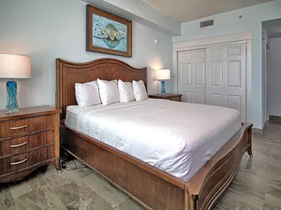 a bedroom with a large bed with a wooden frame at Aqua 0502 in Panama City Beach