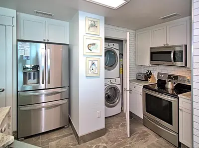 a kitchen with a refrigerator and a washer and dryer at Aqua 0502 in Panama City Beach
