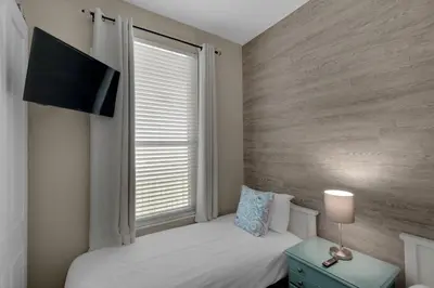 a small bedroom with a bed and a window at Aqua 2207 in Panama City Beach