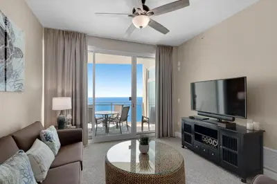 a living room with a couch and a tv at Aqua 2207 in Panama City Beach