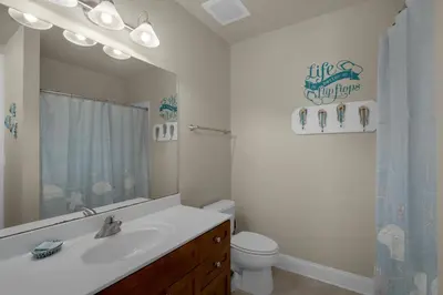 a bathroom with a sink and a toilet and a mirror at Aqua 2207 in Panama City Beach
