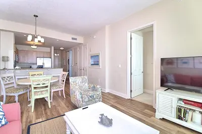 a living room with a table and a dining room at Aqua 2206 in Panama City Beach