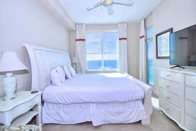 a white bedroom with a bed and a window at Aqua 2206 in Panama City Beach