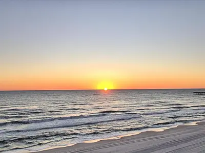 a sunset on a beach with the ocean at Aqua 2206 in Panama City Beach