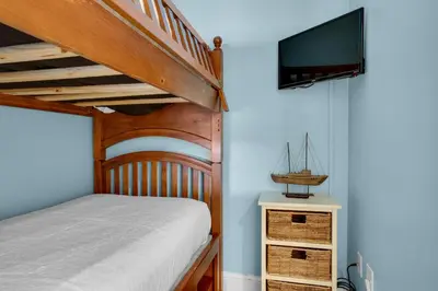 a bedroom with a bunk bed and a tv at Aqua 0610 in Panama City Beach