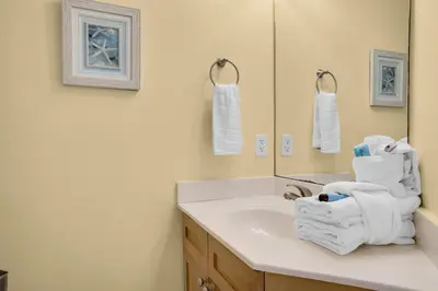 a bathroom with a sink and a mirror and towels at Aqua 0610 in Panama City Beach