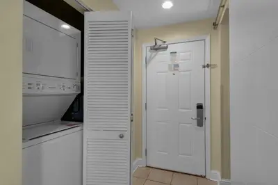 a kitchen with a white door and a microwave at Aqua 0610 in Panama City Beach