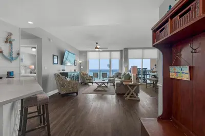 a kitchen and living room with a view of the ocean at Aqua 0302 in Panama City Beach