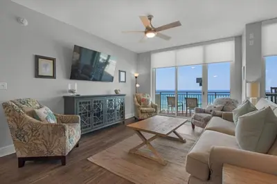 a living room with a couch and chairs and a table at Aqua 0302 in Panama City Beach