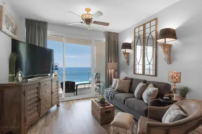 a living room with a couch and a flat screen tv at Aqua 2306 in Panama City Beach