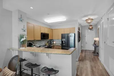 a kitchen with a counter and some chairs in it at Aqua 2306 in Panama City Beach