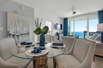 a living room with a glass table and chairs at Aqua 0806 in Panama City Beach