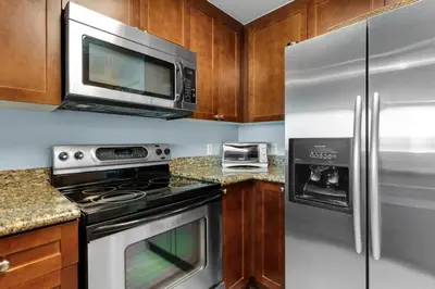 a kitchen with stainless steel appliances and a microwave at Aqua 1008 in Panama City Beach