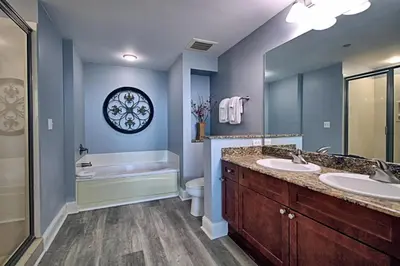 a bathroom with two sinks and a tub and a toilet at Aqua 1008 in Panama City Beach