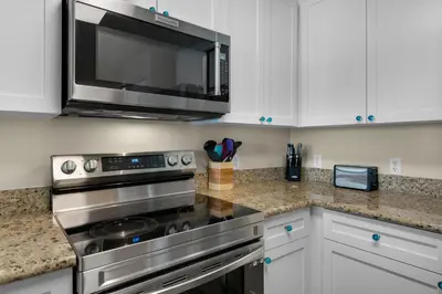 a kitchen with a stainless steel stove and a microwave at Aqua 0210 in Panama City Beach