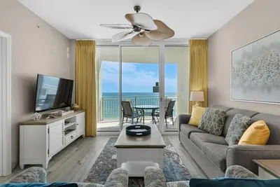 a living room with a couch and a flat screen tv at Aqua 1106 in Panama City Beach