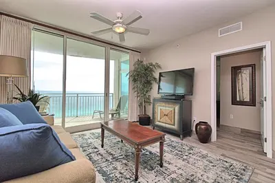 a living room with a couch and a tv and a fireplace at Aqua 1703 in Panama City Beach