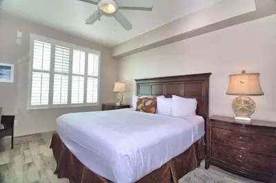 a bedroom with a large bed and a ceiling fan at Aqua 1703 in Panama City Beach