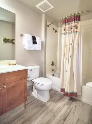 a bathroom with a toilet and a sink and a shower at Aqua 1703 in Panama City Beach