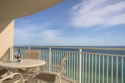 a table and chairs on a balcony with a view of the ocean at Aqua 1703 in Panama City Beach
