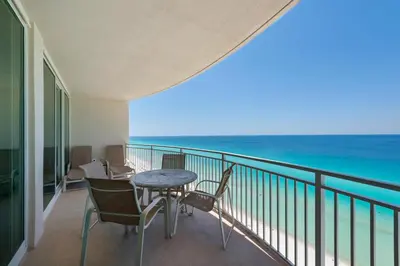 a balcony with a table and chairs and the ocean at Aqua 1703 in Panama City Beach