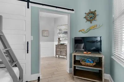 a room with a door and a tv and a table at Aqua 0708 in Panama City Beach