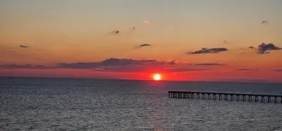a sunset over the ocean with a pier at Aqua 0708 in Panama City Beach