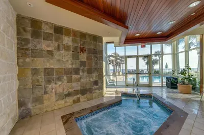 an indoor swimming pool in a room with a stone wall at Aqua 0708 in Panama City Beach