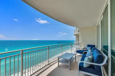 a balcony with chairs and a view of the ocean at Aqua 1501 in Panama City Beach