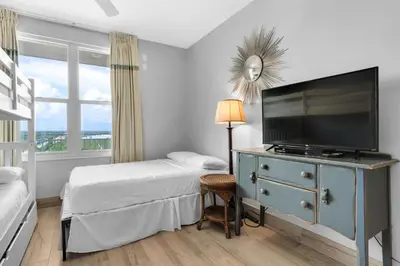 a bedroom with a bed and a television on a dresser at Aqua 1009 in Panama City Beach