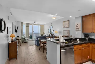 a kitchen and living room with a view of the ocean at Aqua 1009 in Panama City Beach