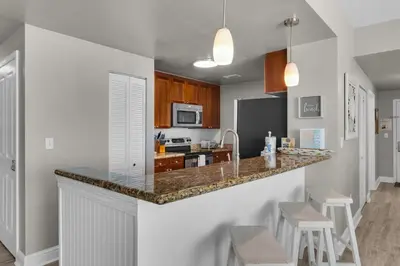 a kitchen with a counter with stools in it at Aqua 0611 in Panama City Beach