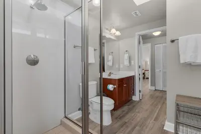 a bathroom with a toilet and a glass shower at Aqua 0611 in Panama City Beach