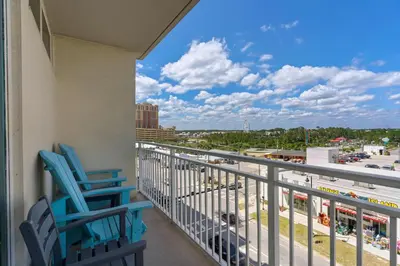 a balcony with two chairs and a view of a parking lot at Aqua 0611 in Panama City Beach