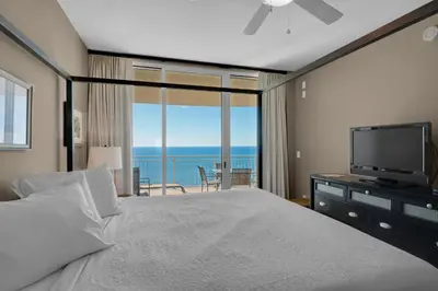 a bedroom with a large bed and a television at Aqua 1708 in Panama City Beach