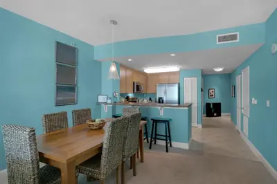 a kitchen and dining room with a wooden table and chairs at Aqua 1708 in Panama City Beach