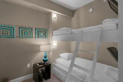 a bedroom with two bunk beds and a lamp at Aqua 1708 in Panama City Beach