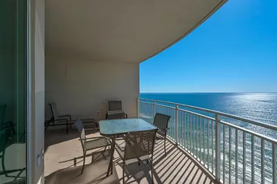 a balcony with a table and chairs and the ocean at Aqua 1708 in Panama City Beach