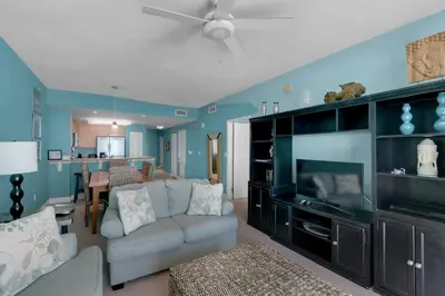 a living room with a couch and a flat screen tv at Aqua 1708 in Panama City Beach