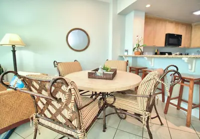 a room with a table and chairs and a kitchen at Aqua 1510 in Panama City Beach