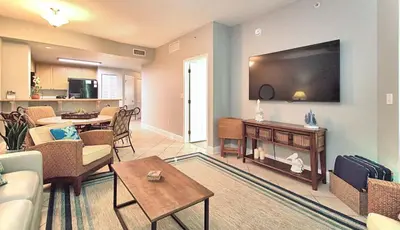 a living room with a large flat screen tv at Aqua 1510 in Panama City Beach