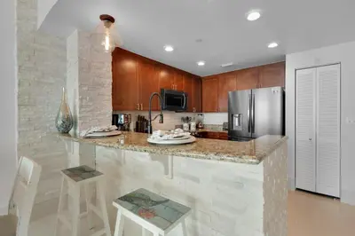 a kitchen with a counter and a refrigerator at Aqua 2110 in Panama City Beach