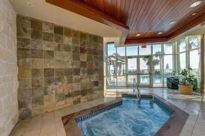 a swimming pool in a room with a tile wall at Aqua 1908 in Panama City Beach