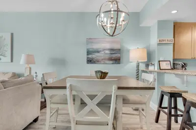a dining room and living room with a table and chairs at Aqua 1908 in Panama City Beach