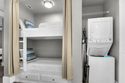 a bedroom with bunk beds with a washer and dryer at Aqua 2304 in Panama City Beach
