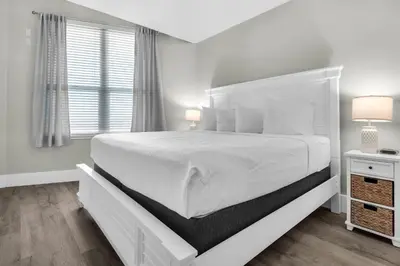a white bedroom with a large bed and a window at Aqua 2304 in Panama City Beach