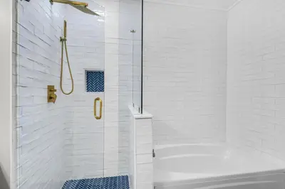 a white bathroom with a tub and a shower at Aqua 2304 in Panama City Beach