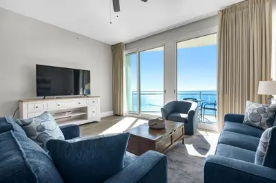 a living room with two blue couches and a television at Aqua 2304 in Panama City Beach
