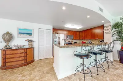 a kitchen with a counter and chairs in a room at Aqua 1001 in Panama City Beach